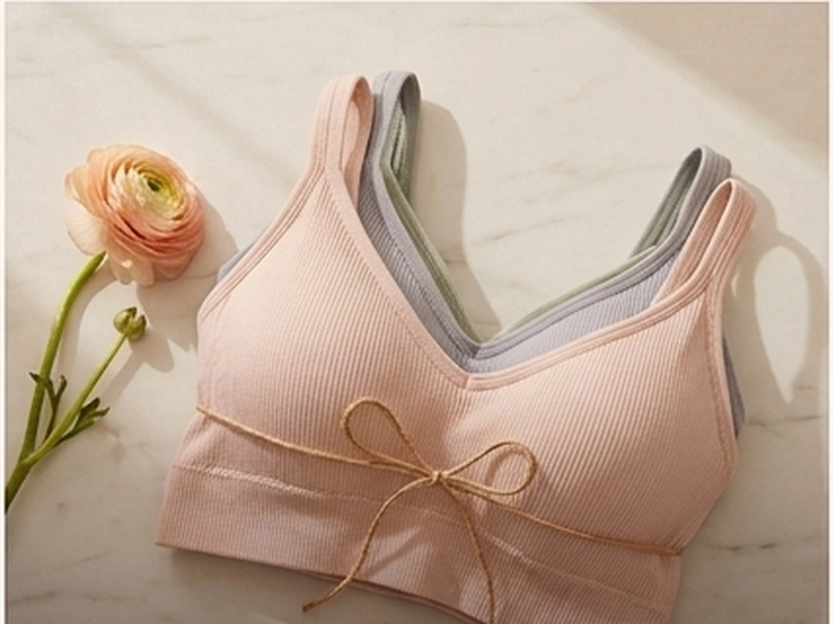 Stack of seamless ribbed Teusy bras in blush, grey and sage